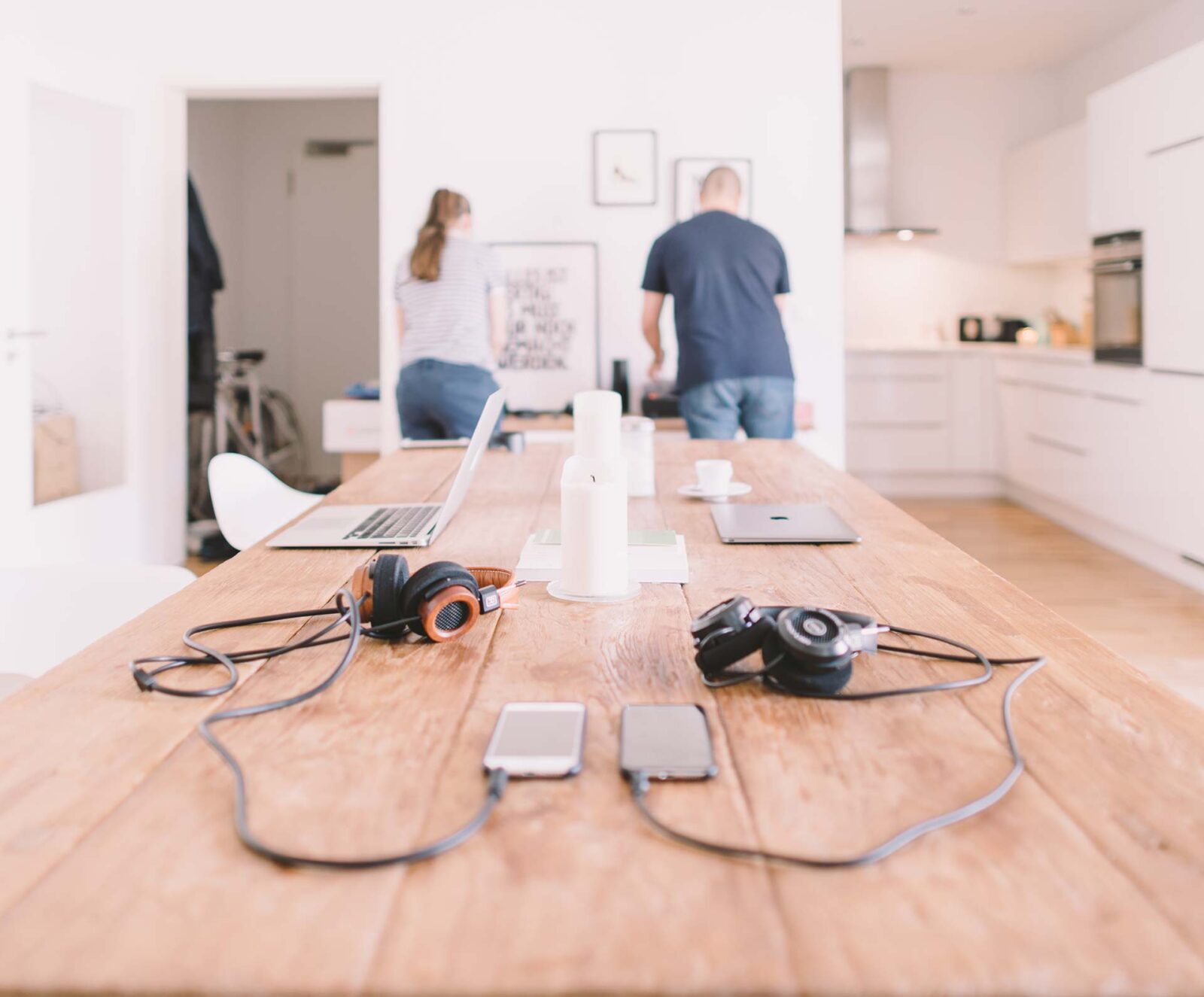 Wooden table with laptops and headphones.